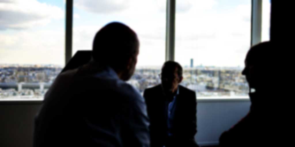 silhouette of three professionals in a office