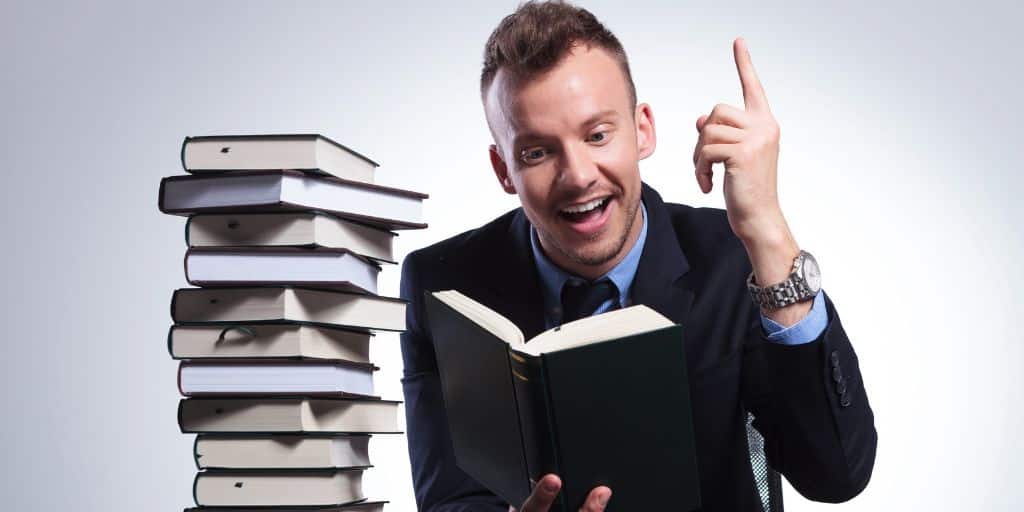 Lawyer reviewing a book with a stack of books next to him