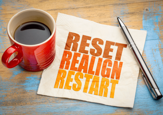 Image of coffee mug with napkin that says reset, realign, restart